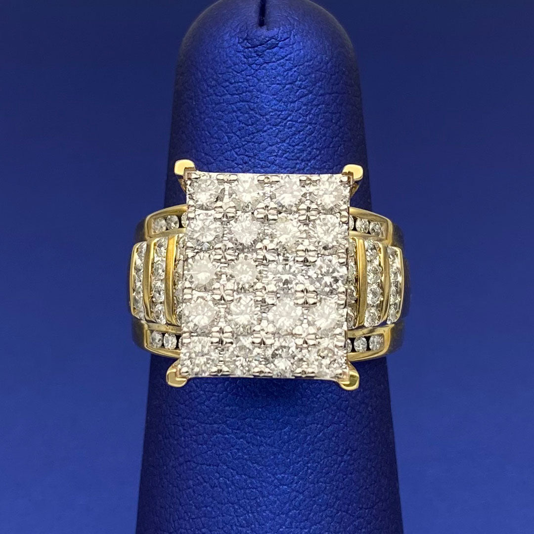 Gold ring with diamond square cluster on a blue finger display